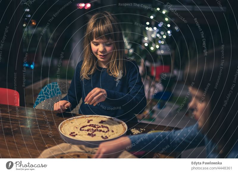 Children decorating mazurek (Polish Easter cake) at home kids family children decorated almond table handmade poland polish tradition easter cake nuts raisins