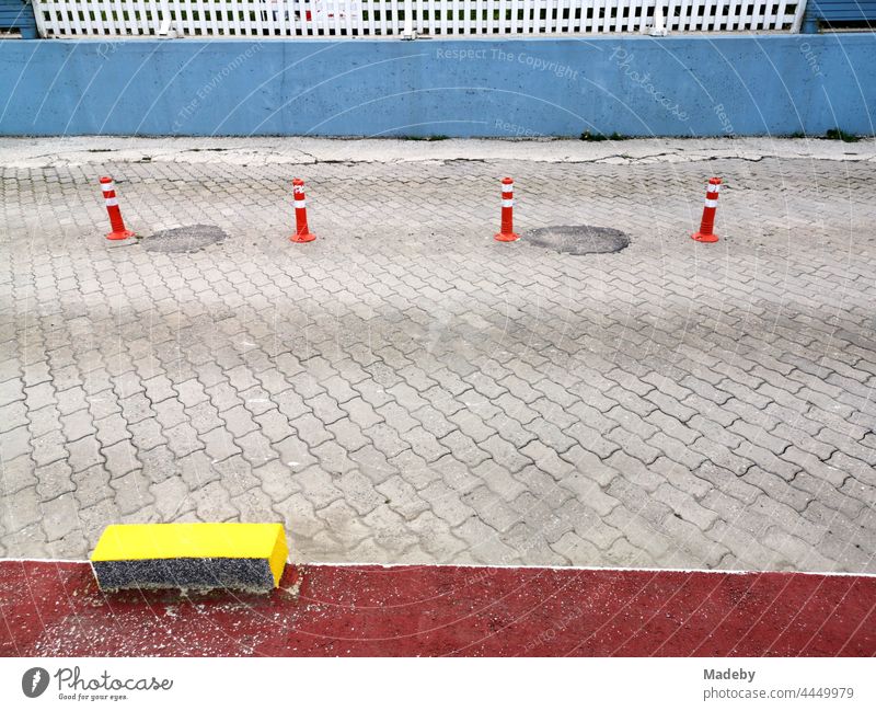 Coloured plastic road marking and bollards on grey composite paving in Sapanca near Adapazari in Sakarya Province, Turkey Street pavement paving stone Gray