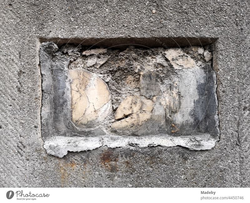 Grey stone post with rectangular opening and hay-crumbling stone at the entrance of a villa at the Senckenberganlage in the west end of Frankfurt am Main in Hesse