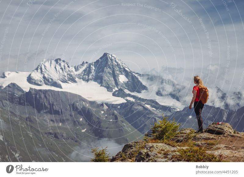 Young woman with backpack looking at the mountain Großglockner in East Tyrol Alps Grossglockner Eastern Tyrol Hiking Peak vacation Backpack Austria hike outlook