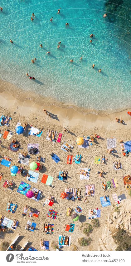 Tourists on shore of island against sea tourist rock nature highland landscape resort vacation coast ibiza sandy ripple waterfront spain scenic traveler