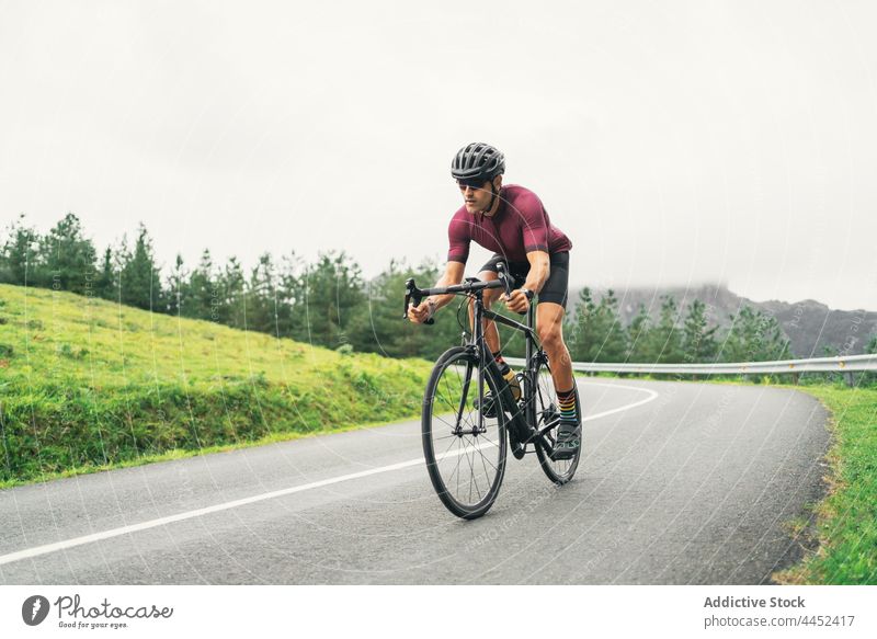 Bicyclist riding bike during training on countryside road bicyclist ride sport racing bicycle cycling workout activity man route direction road bicycle