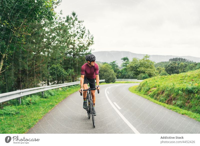 Bicyclist riding bike during training on countryside road bicyclist ride sport racing bicycle cycling workout activity man route direction road bicycle