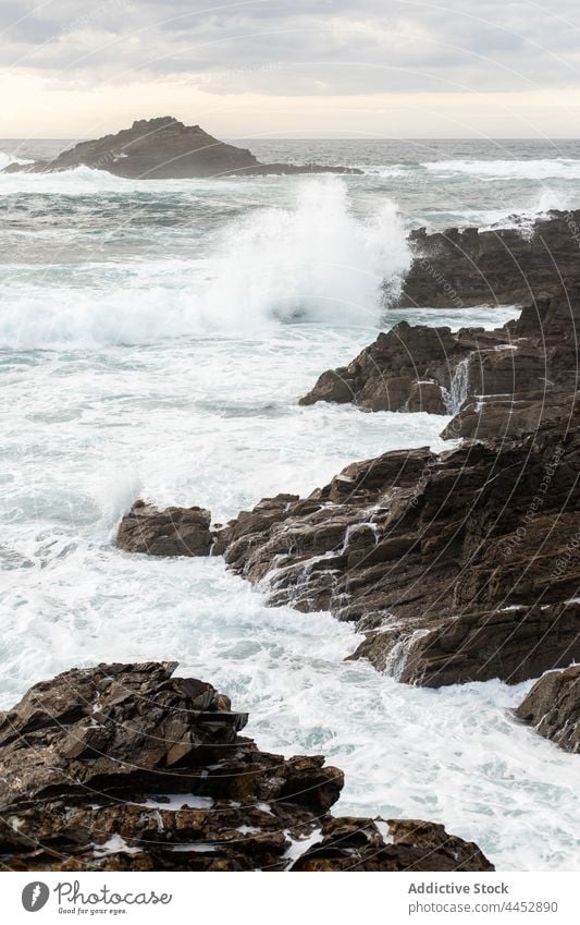 Stormy sea with splashing foam against rocks energy power motion storm nature seascape landscape highland sky cloudy splatter fast dynamic dramatic weather