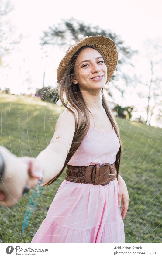 Cheerful teen holding crop friend by hand on meadow holding hands follow me cheerful spend time interact sincere portrait together partner smile candid content