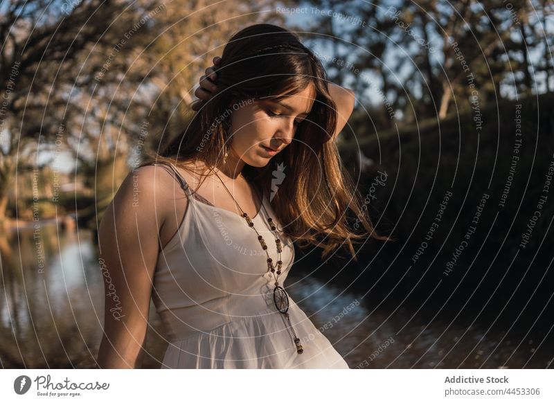 Tender teen touching hair against river in park touch hair reflective charming gentle allure pleasant feminine teenage natural pure tender idyllic beauty