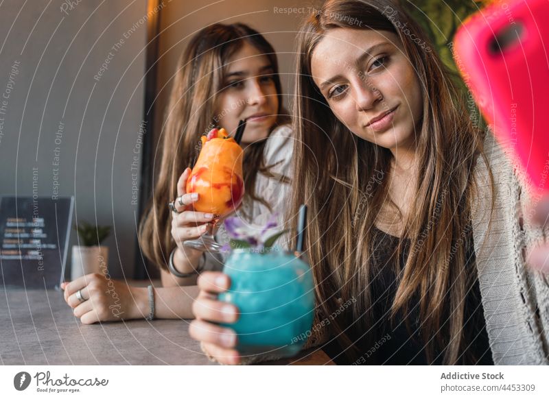 Girlfriends with cocktails taking selfie on smartphone in street cafeteria girlfriend self portrait memory moment spend time using gadget urban best friend