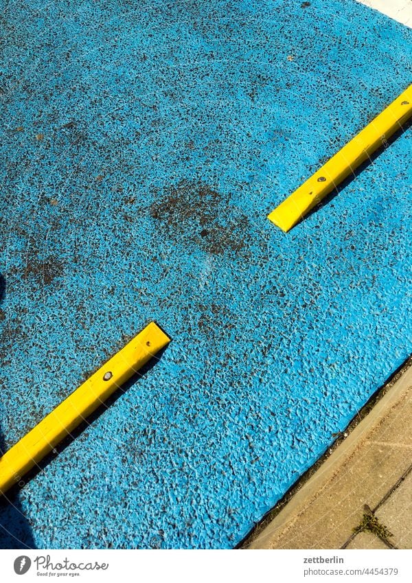 Yellow flat bollards on blue asphalt Alley Summer Town city centre Tourism tourism Lane markings Street cycle path Turn off Asphalt Corner Cycle path Clue edge