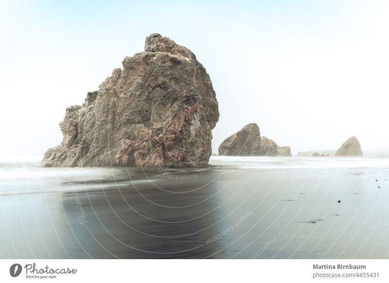 Long exposure of rocks on the Oregon Pacific coast in the morning fog mist haze oregon coast state scenic corridor highway 101 landscape travel hiking nature