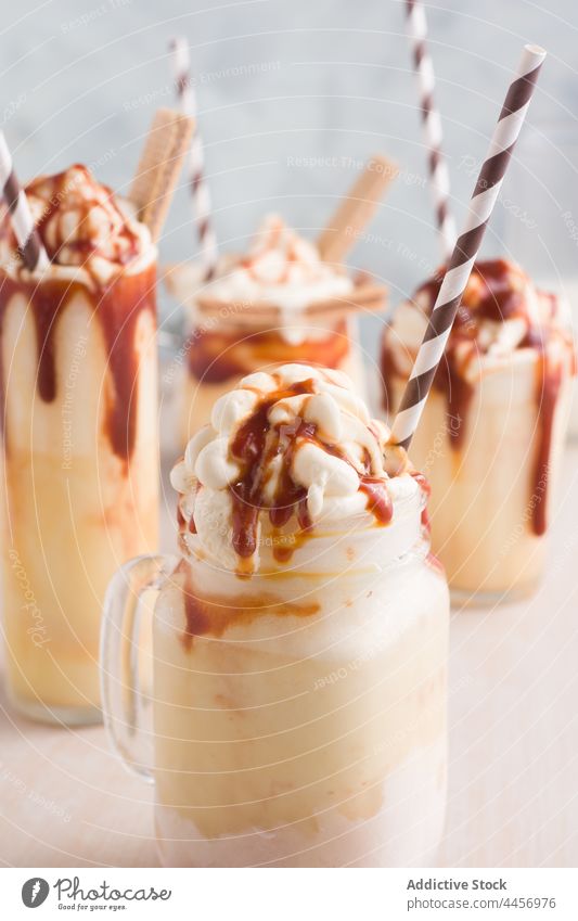 Tasty caramel milkshakes in glasses on table assorted serve wafer cookie sweet ice cream vanilla delicious drink straw tasty treat cold yummy dairy refreshment