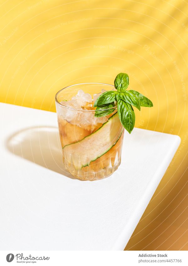 Refreshing cocktail with cucumber and basil rum glass alcohol serve table drink cold refreshment beverage slice delicious portion vegetable ingredient cube