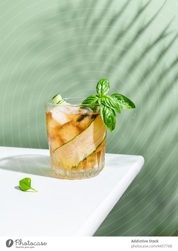 Refreshing cocktail with cucumber and basil rum glass alcohol serve table drink cold refreshment beverage slice delicious portion vegetable ingredient cube