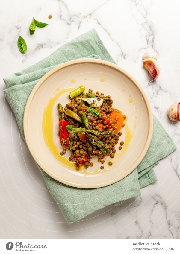 Lentil salad on plate on table lentil dish vegetable tasty serve meal cuisine herb food gourmet vegetarian vegan asparagus basil carrot pepper garlic organic