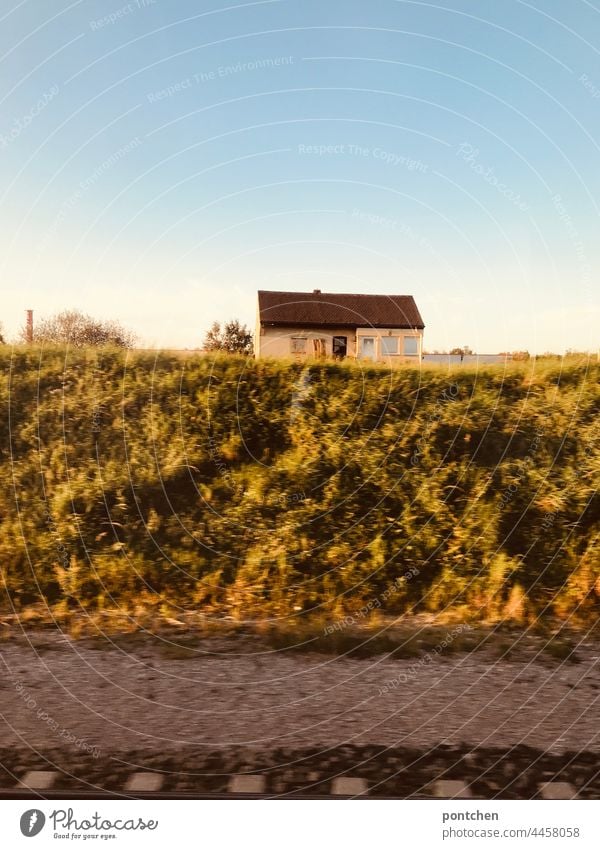 View from the train. Golden autumn. A small old house on the track train ride Autumn Sun golden autumn rail gleiß Landscape forsake sb./sth. public transport