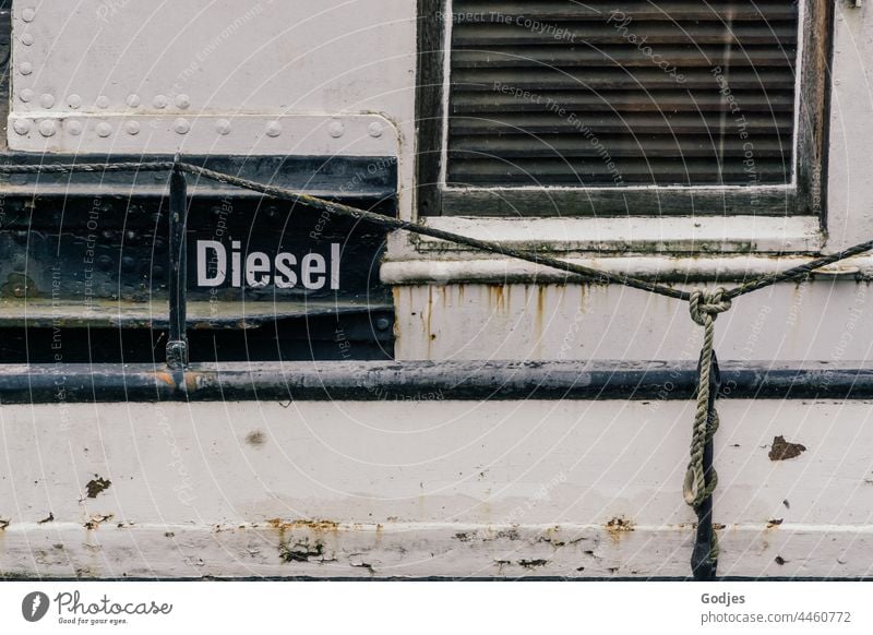 Steel wall of a ship with window and the inscription 'Diesel Steel construction Wall (building) Navigation Window Fuel Metal Exterior shot Steel carrier