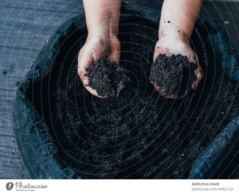 Kid showing soil in hands against flower pot child demonstrate reach out dry natural botany kid horticulture floral plant childhood ground garden cultivate