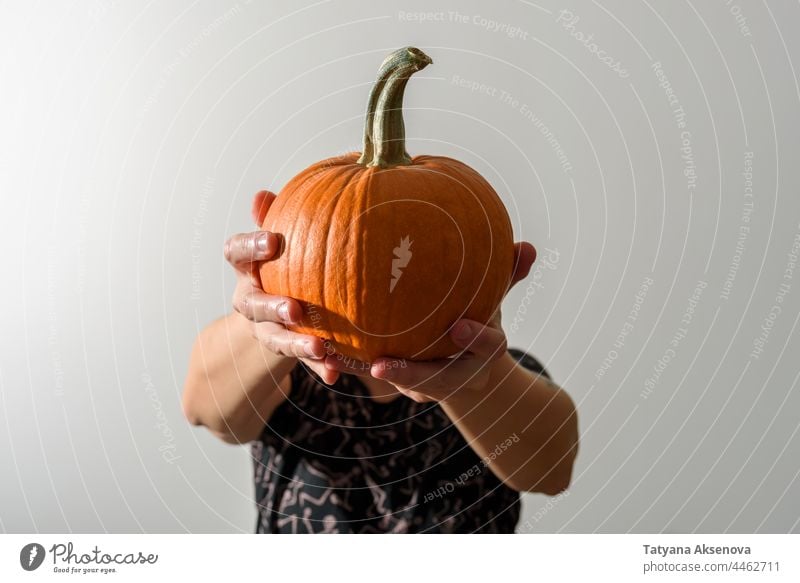 Woman holding pumpkin instead of head woman halloween female portrait jack-o-lantern hands harvest spooky creepy faceless anonymous anonymity