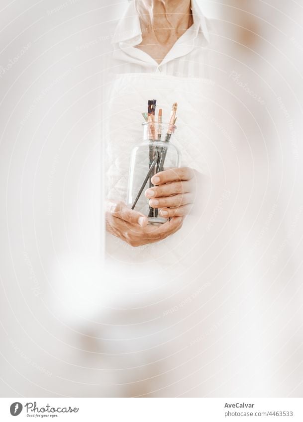 Woman artist painter holding a bunch of paint brush. Painter artist and paintbrush in studio, Crystal bottle, indie style, hipster, creative concept creativity