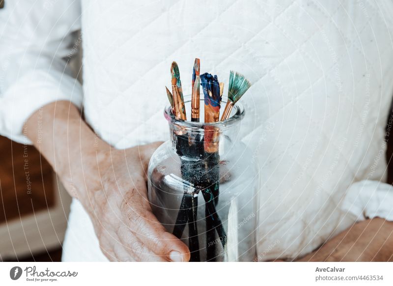 Woman artist painter holding a bunch of paint brush. Painter artist and paintbrush in studio, Crystal bottle, indie style, hipster, creative concept creativity