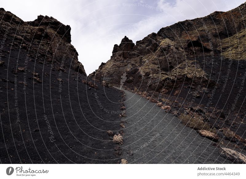 Volcano and ridges under cloudy sky in daytime volcano mount highland nature cuervo landscape geology barren massive mountain lanzarote air spain tinajo island