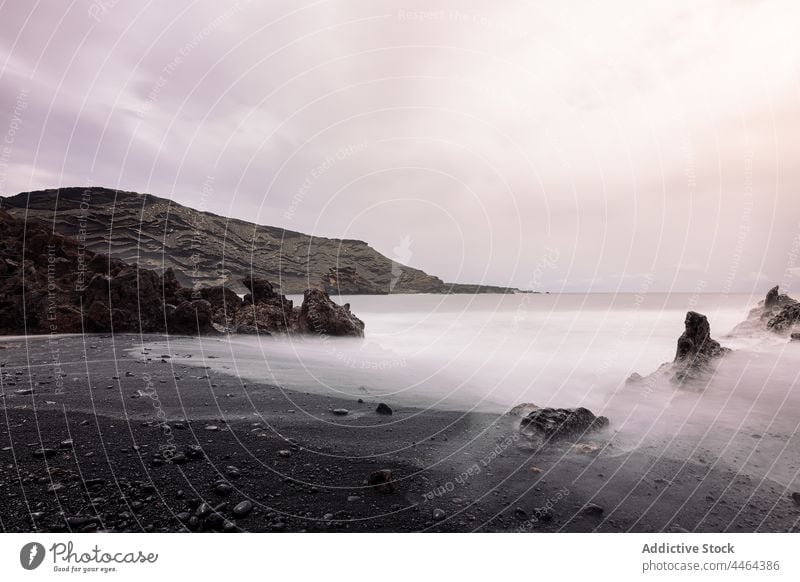 Ocean shore and volcano under cloudy sky in foggy weather ocean coast nature highland landscape island sea beach mist mountain water marine scenery picturesque