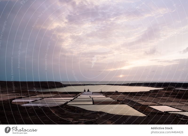 Salt flats against lagoon and ocean in sunlight sea flat mountain sky nature landscape highland seascape horizon island janubio salinas marine scenery