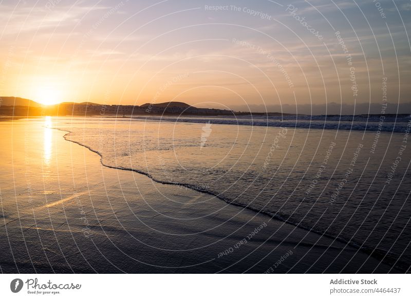 Rippled sea against mounts under cloudy sky at sunset beach mountain nature landscape highland sundown island shore evening shiny ocean scenery picturesque