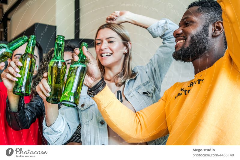 Friends having fun while drinking beer together. home group friends happy friendship party smile cheers female smiling happiness enjoy man woman indoors bottle