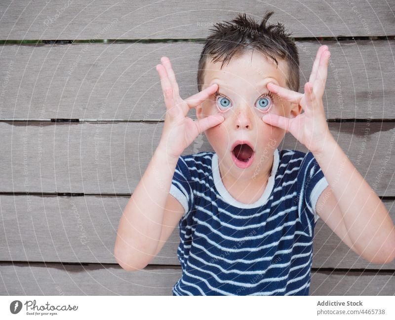 Funny boy making surprised face with mouth opened amazed wow make face fun grimace shock astonish expressive omg disbelief childhood playful human face funny