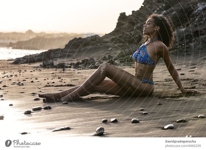 Woman in bikini in a volcanic beach woman ethnic island seaside beautiful fit santo antao smile african cape verde holiday horizontal happy black curly hair