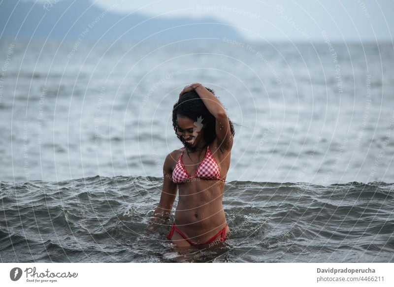 Woman in bikini in a volcanic beach woman ethnic island seaside beautiful fit santo antao smile african cape verde holiday horizontal happy black curly hair