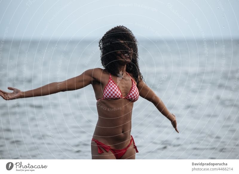 Woman in bikini in a volcanic beach woman ethnic island seaside beautiful fit santo antao smile african cape verde holiday horizontal happy black curly hair