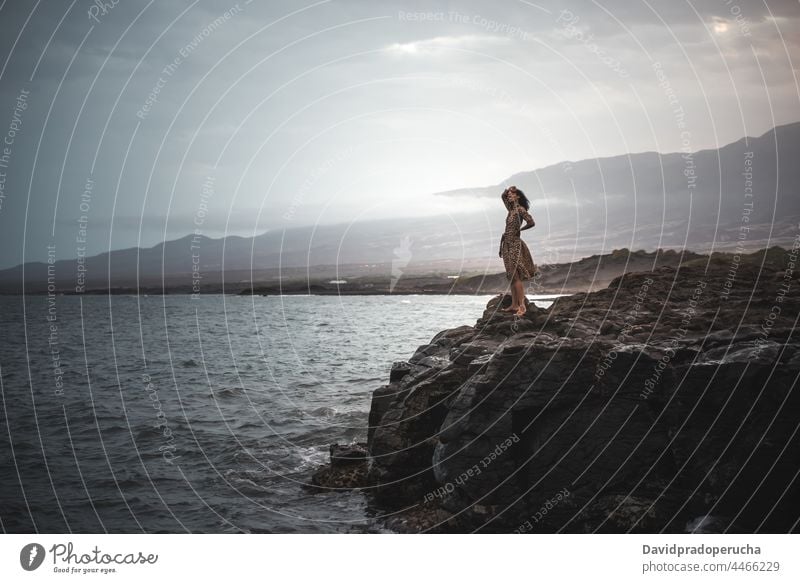 Woman standing in a cliff seashore woman seaside horizontal black ethnicity copy space outdoors holiday body lifestyle exotic water ocean sun one santo antao