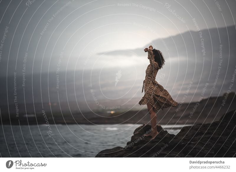 Woman standing in a cliff seashore woman seaside horizontal black ethnicity copy space outdoors holiday body lifestyle exotic water ocean sun one santo antao