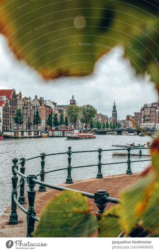 View of buildings and canals in Amsterdam, Netherlands dutch Zwanenburgwal Amstel Gracht canal trip Excursion boat boat tour Autumn coloured leaves River