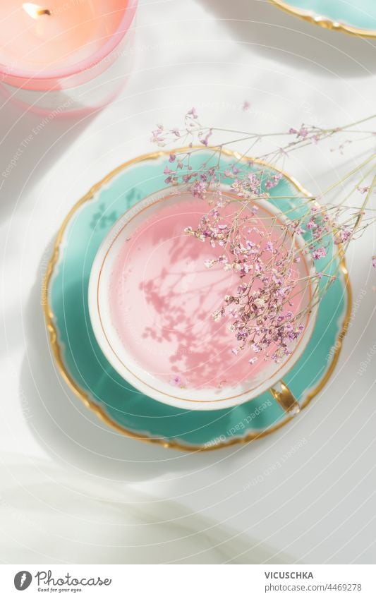 Turquoise porcelain cup with pink tea and plate on light background with sunlight turquoise design table teacup beverage blossom elegant spring style flower