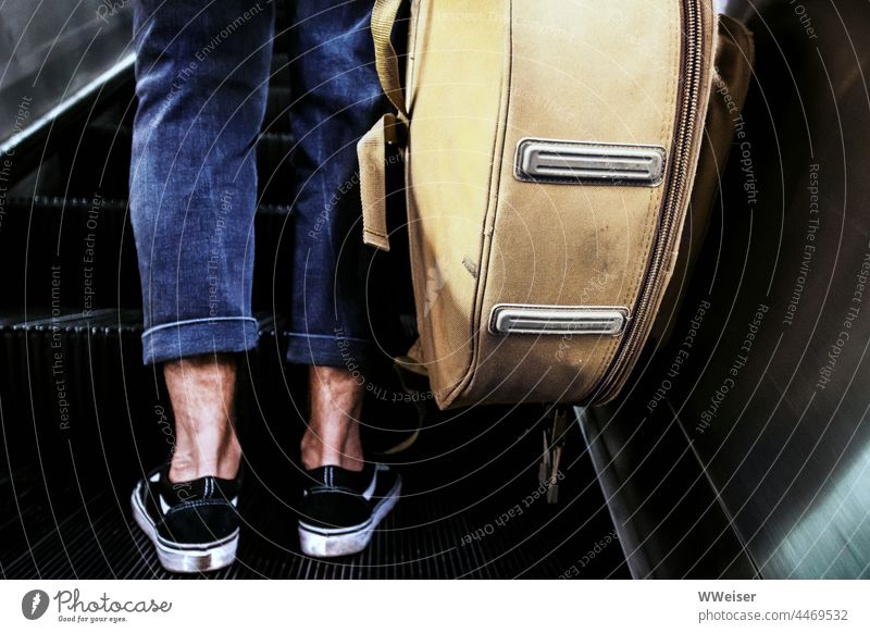 A young musician stands on the escalator with his instrument, on his way to the next gig. Escalator Metro boot In transit Man Legs Modern Athletic Musician