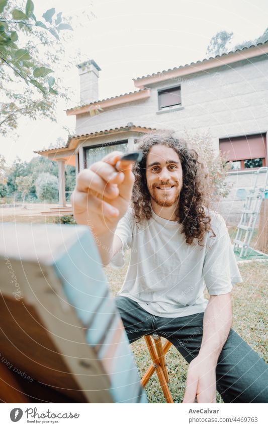 Portrait of Artist Working. Close-up Shot portrait, long hair young man painting oil person artist brush canvas indoor inspiration occupation painter talent