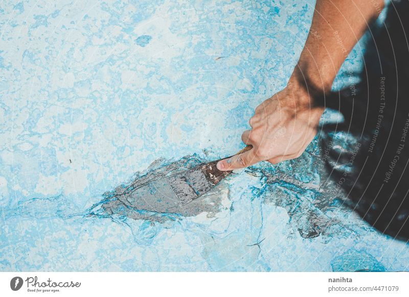 Close up of a man fixing the floor of a pool maintenance crack diy putty putty knife palette palette knife work job home craft hard hard work physical strong