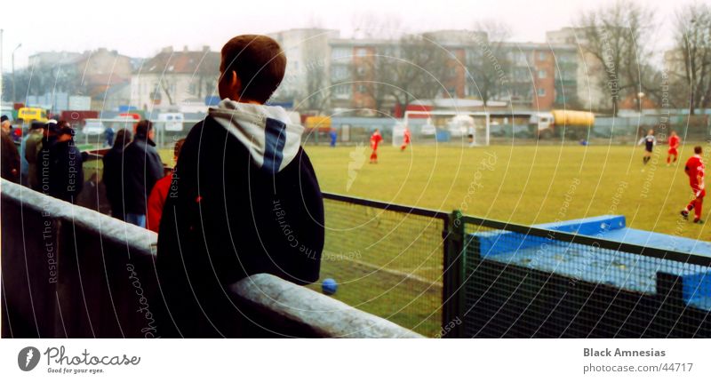 a true balancing act Stadium Wall (barrier) Man Boy (child) black jacket Soccer Human being Back comfortable seat