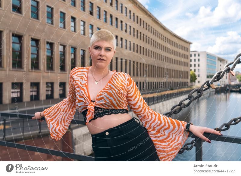 power and beauty: portrait of a young woman with short blonde hair on a bridge in Berlin beautiful berlin blouse business bustier canal casual caucasian city