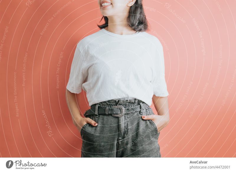 Teen girl standing over isolated and smiling colorful background. Young woman dressed in white t-shirt, blank space t shirt copy space, design, shopping commercial shot