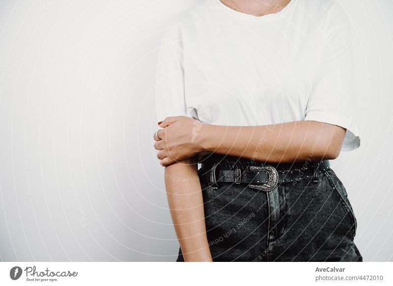 Teen girl standing over isolated and smiling colorful background. Young woman dressed in white t-shirt, blank space t shirt copy space, design, shopping commercial shot