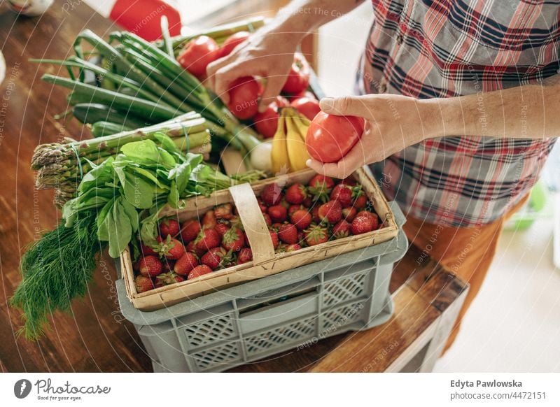 Man unpacking his groceries in the kitchen at home hand people person unpacking groceries agriculture asparagus basket box buying cooking crate delicious