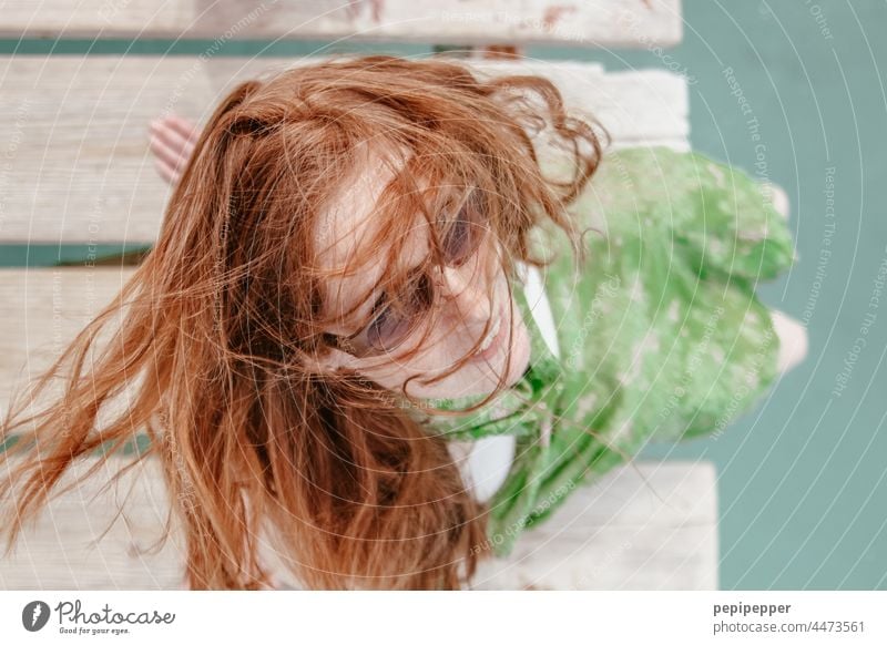 redhead woman in sunglasses sitting on a jetty photographed from above red-haired woman red hair Red-haired Redheads Woman Face of a woman women portrait pretty