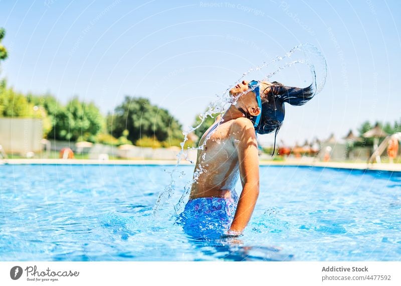 Boy in swimsuit splashing water man boy pool swimwear hair resort male wet summer poolside young holiday leisure vacation aqua charming stand pleasure sunlight