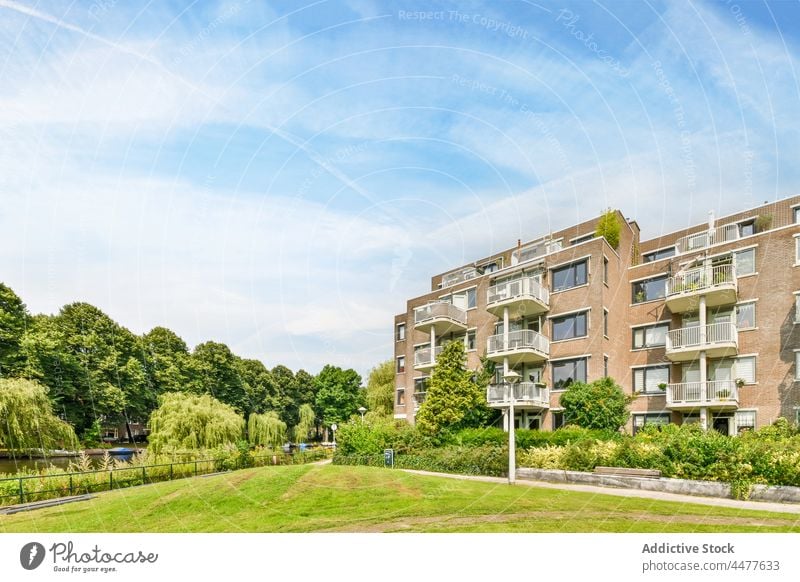 Modern residential house with green trees and bushes exterior architecture facade building contemporary modern construction district property lush neighborhood