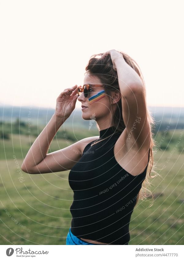 Woman with a rainbow on her face liberty lgtbi lgtbiq freedom lifestyles paint peace purple love magenta people retro lesbian color image colorful