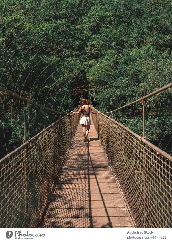 Traveling woman on bridge in forest traveler suspension park footbridge explore adventure female fragas do eume spain nature destination explorer woodland woods