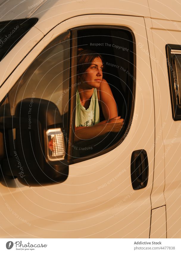 Dreamy woman in traveling camper in evening traveler van sunset dreamy tranquil sundown female spain enjoy admire serene peaceful calm window freedom vacation